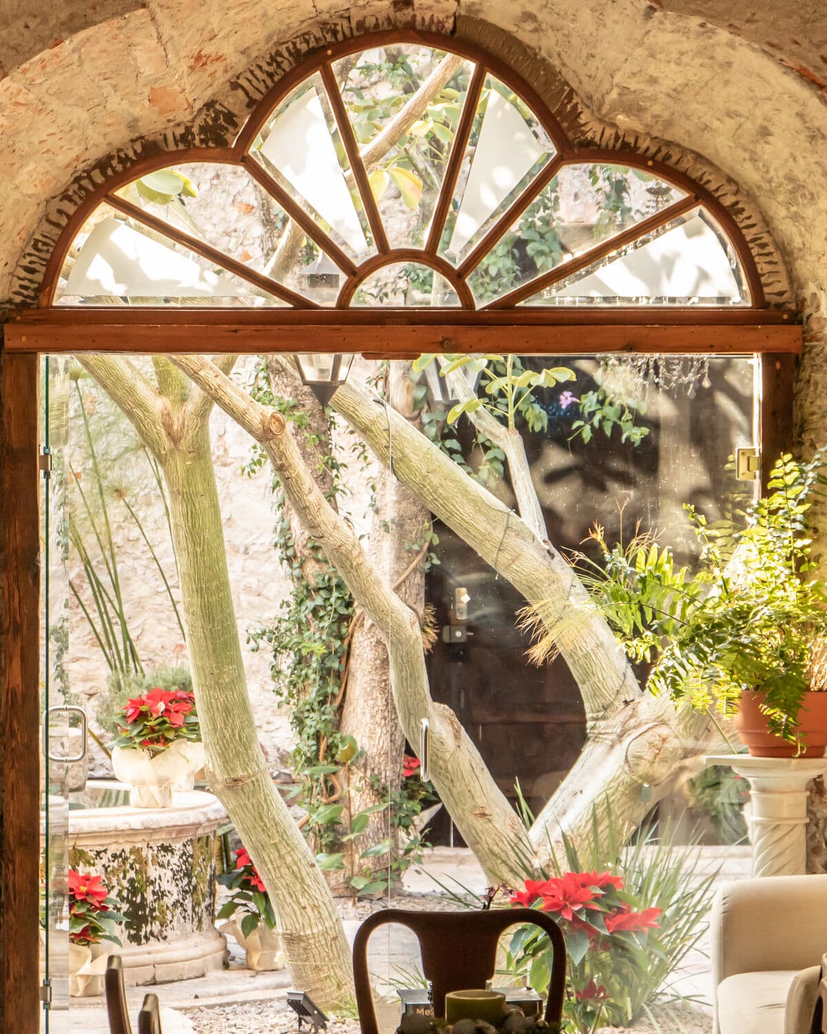 The sitting room of the San Miguel house under the stone arch, with the timber fanlight open onto the courtyard