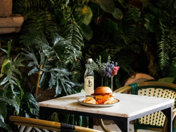 A sandwich served at a marble table on Aura's terrace, among the greenery and bistro chairs