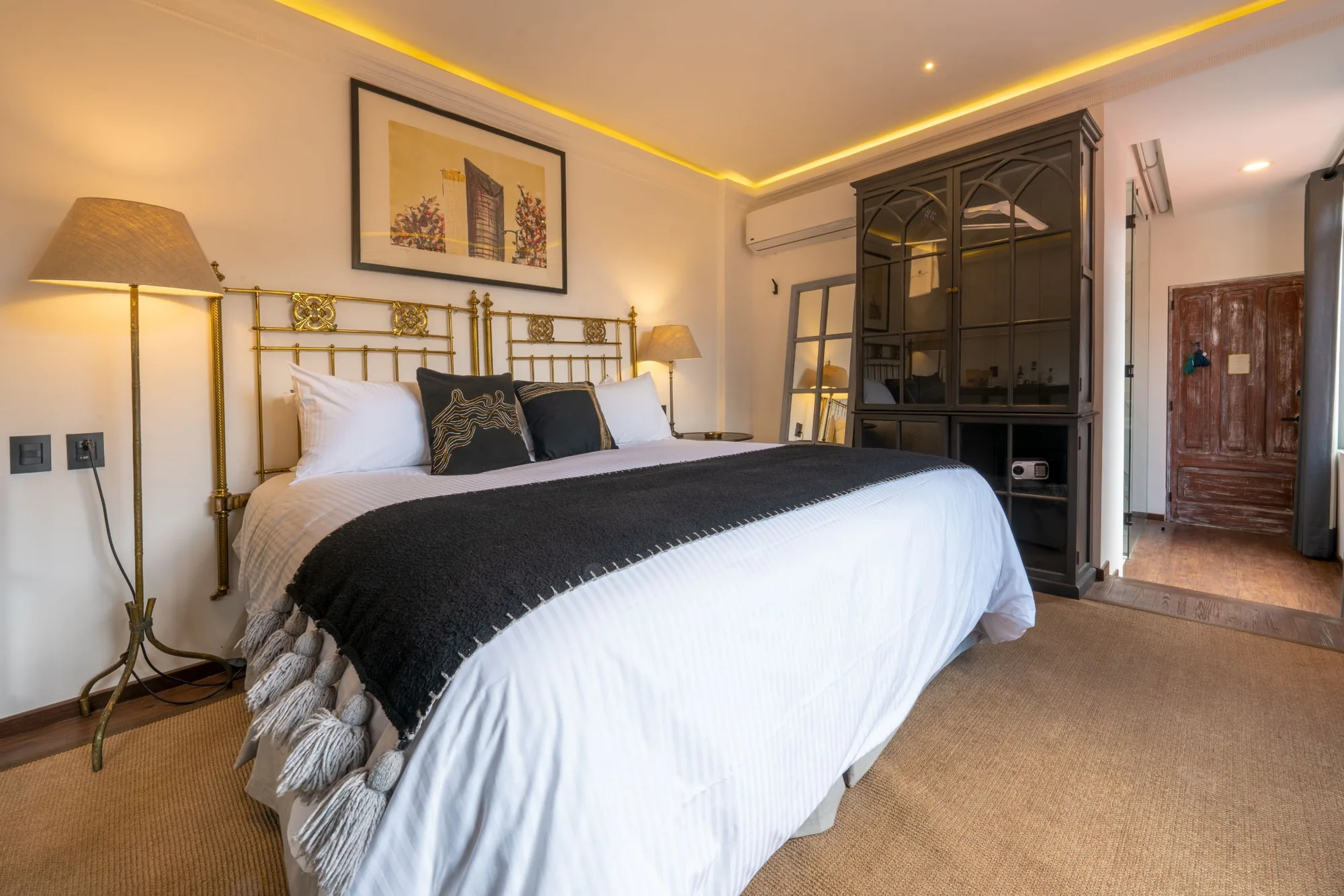 Room with a brass headboard and a cabinet with an in-room safe