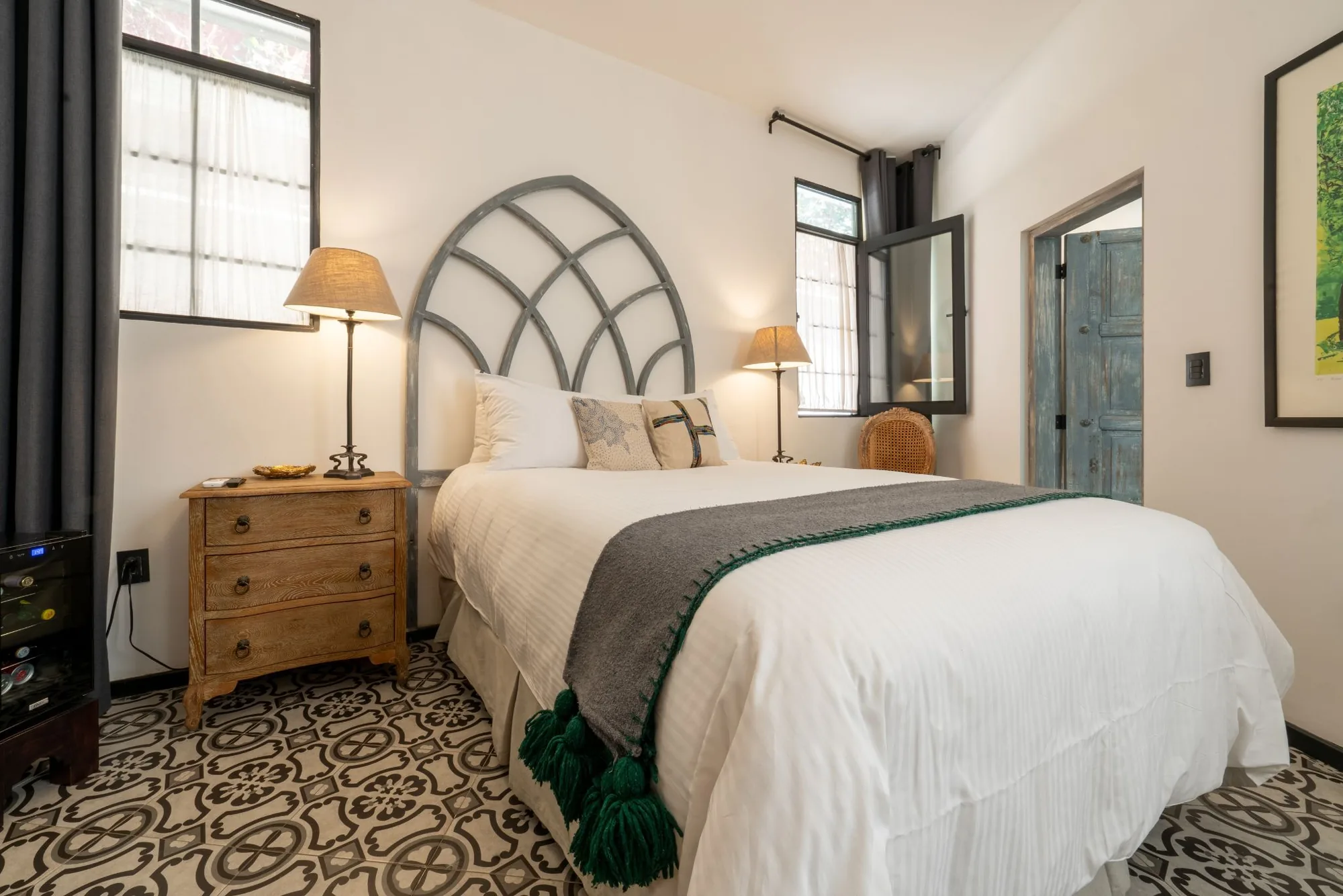 Room with an arched cut-out headboard and talavera mosaic floor