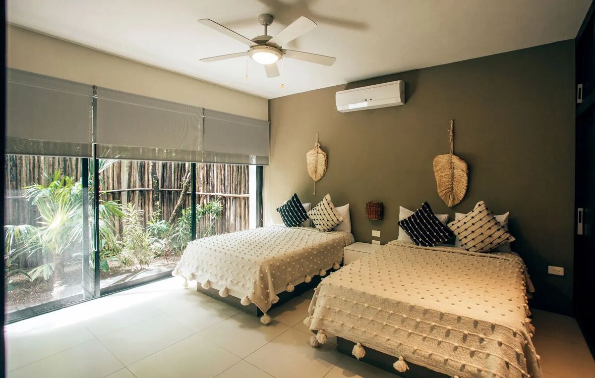 A room with two beds, opening through sliding glass onto the bamboo garden