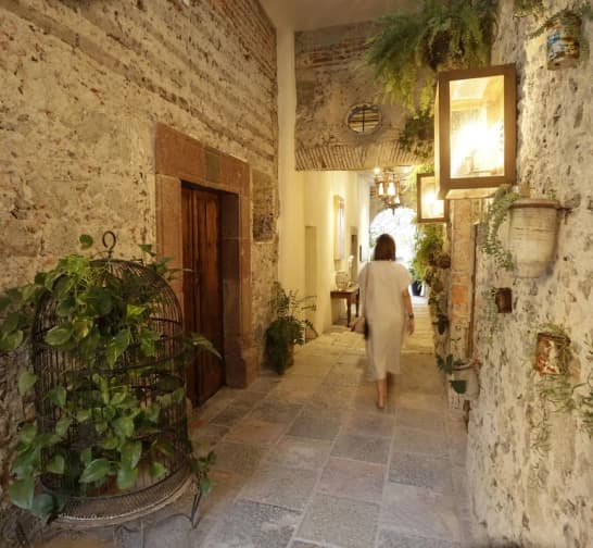 The dining room at Orchid House San Miguel under a stone arch, opening onto the courtyard and its fountain
