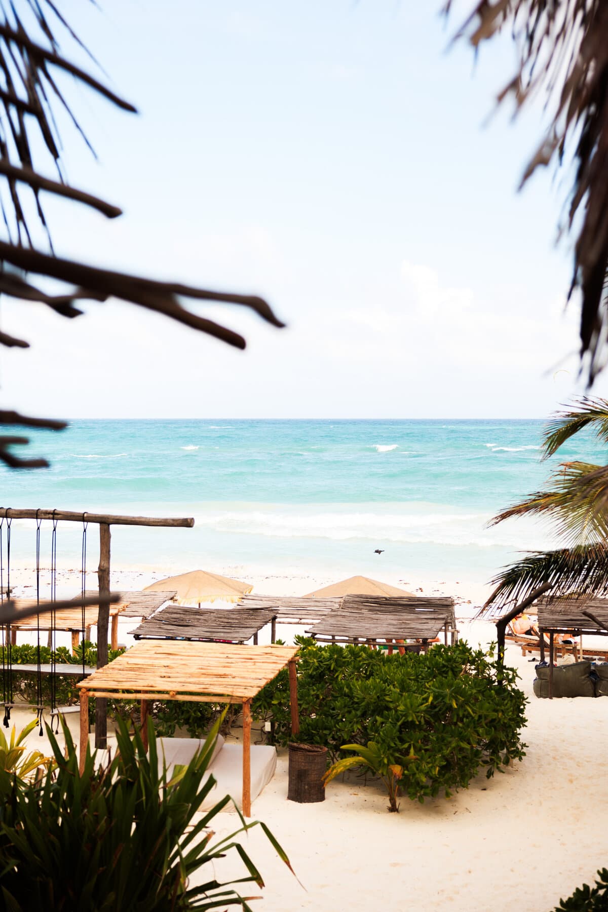 The palapa umbrella facing the ocean, with waves breaking on the white sand