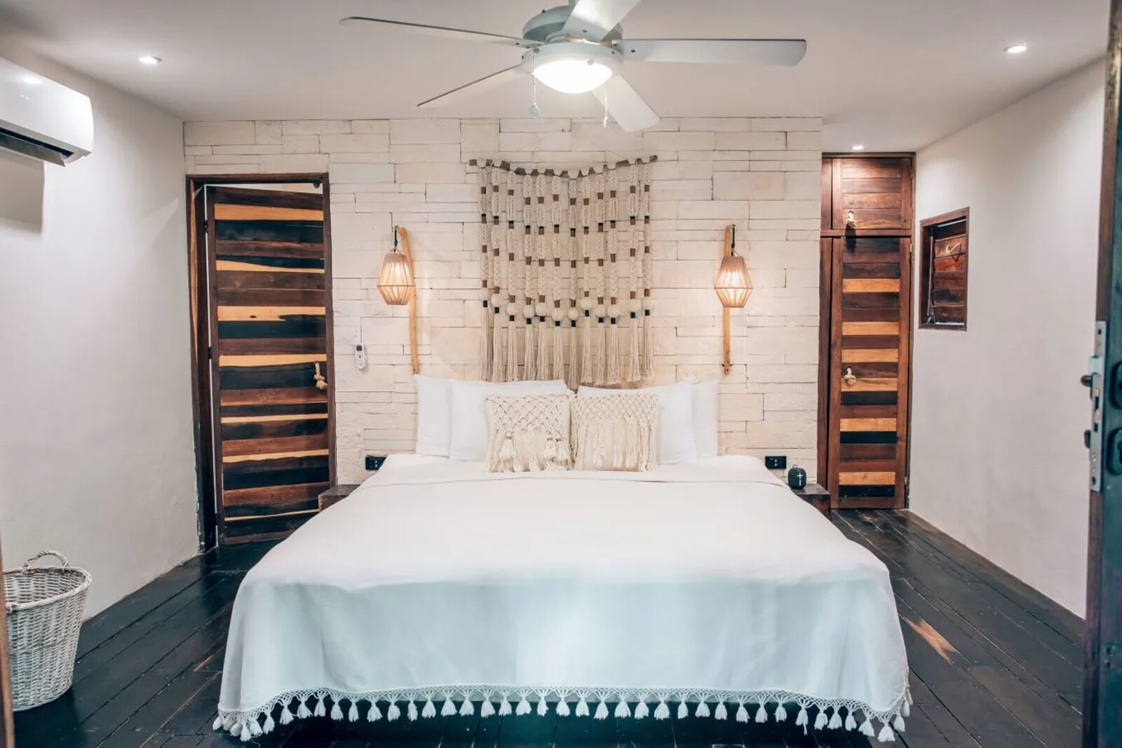 Room with a macramé wall hanging against a stone wall, between two carved timber doors