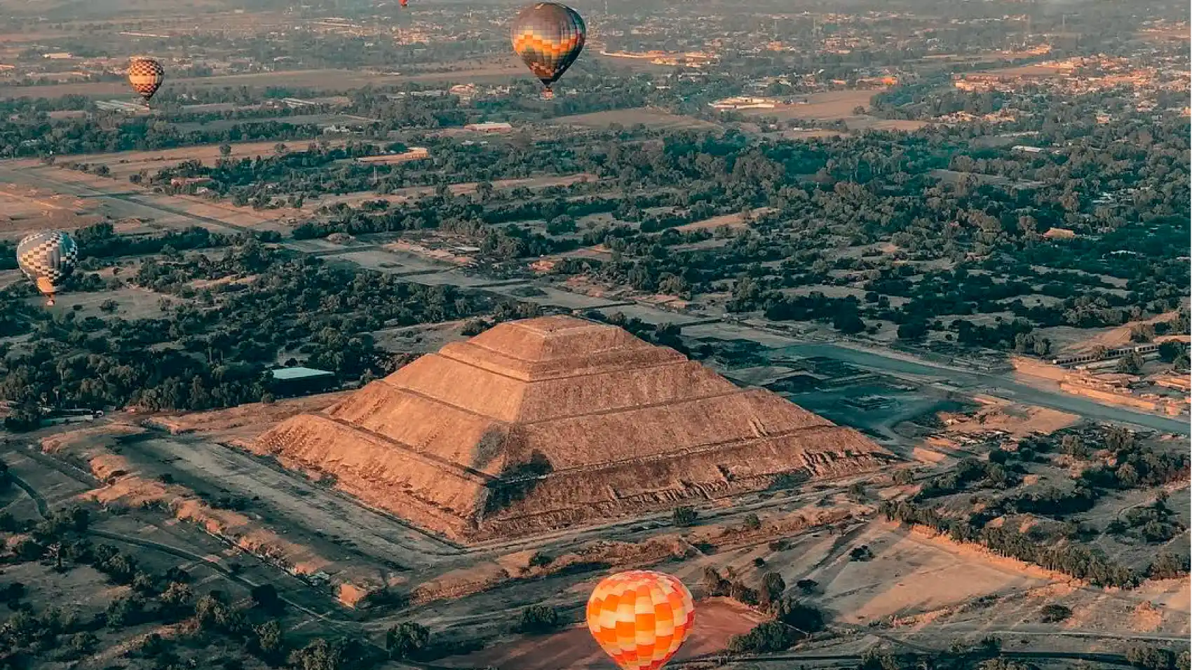 Hot air balloons flying over the Pyramid of the Sun at Teotihuacán at sunrise