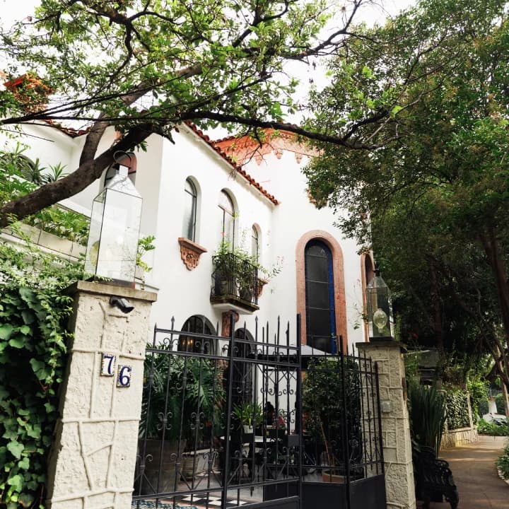 The facade of the Polanco house, with its wrought-iron gate and the number 76 at the entrance, among trees